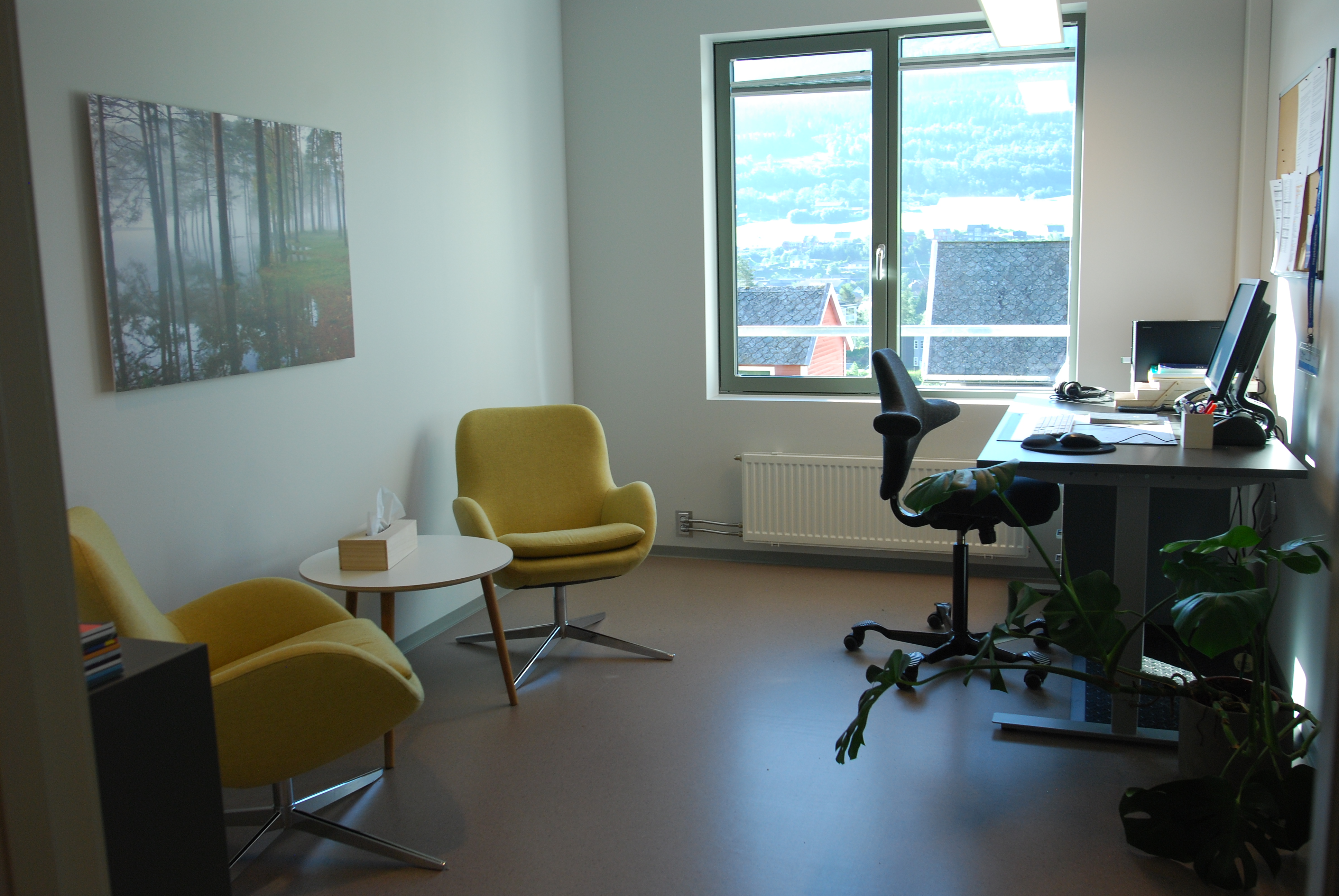 Eit rom med skrivebord og stolar